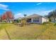 Backyard with screened patio, lush landscaping, and grassy area at 9470 Sw 66Th Loop, Ocala, FL 34481