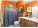 Bathroom with orange walls, wood vanity, and shower/tub combo at 9470 Sw 66Th Loop, Ocala, FL 34481