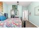 Bedroom with patterned bedding, mirrored closet doors, and a view of a hallway at 9470 Sw 66Th Loop, Ocala, FL 34481