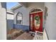 Inviting entryway with a red door, brickwork, and a cozy bench at 9554 Sw 93Rd Loop, Ocala, FL 34481