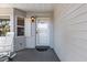 White front door entry with a welcoming mat, sidelights, and a porch light at 9802 Sw 88Th Ter # A, Ocala, FL 34481