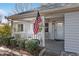 Charming front porch with rocking chairs, American flag, and lush greenery at 9802 Sw 88Th Ter # A, Ocala, FL 34481