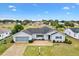 Single-story home with a two-car garage and landscaped yard, located on a golf course at 9836 Se 175Th Pl, Summerfield, FL 34491