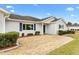 House entrance with a stone walkway, landscaping, and light grey siding at 9836 Se 175Th Pl, Summerfield, FL 34491