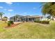 Backyard view of house with pool and well-manicured lawn at 9836 Se 175Th Pl, Summerfield, FL 34491