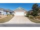 Tan house with a two-car garage and neatly landscaped yard at 9945 Sw 100Th Terrace Rd, Ocala, FL 34481