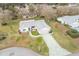 Aerial view of a single-story house with a large driveway and a well-maintained lawn at 10882 Sw 62Nd Ave, Ocala, FL 34476