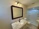 Bathroom featuring granite countertop, mirror, and shower with white tile and glass door at 10895 Sw 90Th Ter, Ocala, FL 34481