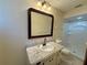 Bathroom featuring white cabinets, modern faucet, granite countertop, and shower with white tile and glass door at 10895 Sw 90Th Ter, Ocala, FL 34481