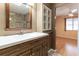 Bathroom vanity with sink, mirror, and access to bedroom at 10918 Se 50 Ave, Belleview, FL 34420