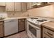 Kitchen with wood cabinets, white appliances, and tile floor at 10918 Se 50 Ave, Belleview, FL 34420