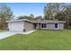 Newly constructed home with gray siding, attached garage, and grassy lawn at 11365 N Ortega Pt, Citrus Springs, FL 34433