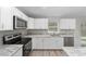 White shaker cabinets, granite countertops, and stainless steel appliances in a bright kitchen at 13 Bahia Trace Loop, Ocala, FL 34472