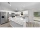 Modern kitchen featuring white cabinets, granite island, and stainless steel appliances at 13 Bahia Trace Loop, Ocala, FL 34472