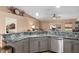 Modern kitchen with gray cabinets, granite countertops, and stainless steel appliances at 13165 Sw 107Th St, Dunnellon, FL 34432