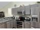 Modern kitchen with gray cabinets, granite countertops, and stainless steel appliances at 13165 Sw 107Th St, Dunnellon, FL 34432