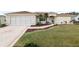 Tan one-story house with palm trees and landscaped yard at 13560 Se 90Th Ct, Summerfield, FL 34491