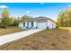 White house with gray roof, attached garage, and concrete driveway at 14108 Se 42Nd Ter, Summerfield, FL 34491