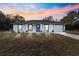 House exterior at sunset showcasing gray roof, white walls, and blue door at 14108 Se 42Nd Ter, Summerfield, FL 34491