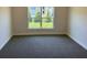 Carpeted bedroom with a large window looking out onto a wooded area at 2154 Nw 23Rd Loop, Ocala, FL 34475