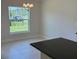 The dining area features a chandelier, window view to the outside, and tiled flooring at 2154 Nw 23Rd Loop, Ocala, FL 34475