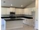 Modern kitchen featuring white cabinets, black countertops, and stainless steel appliances at 2154 Nw 23Rd Loop, Ocala, FL 34475
