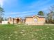 Tan house with gray metal roof, walkway, and landscaping at 22287 Sw Mango Ln, Dunnellon, FL 34431