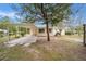 Back of the house with attached carport and a view of the backyard surrounded by trees at 2501 Nw 20Th St, Ocala, FL 34475