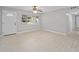 Living room features tile floors, a ceiling fan, a large window, and a white front door at 2501 Nw 20Th St, Ocala, FL 34475