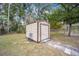 Exterior shot of a shed with neutral walls and door and a gray brick path at 2501 Nw 20Th St, Ocala, FL 34475