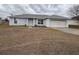 Front view of a single story house with a garage and yard at 28 Juniper Loop Ter, Ocala, FL 34480