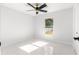 Bright bedroom with ceiling fan, window, and marble-look tile flooring at 3690 Se 133Rd Pl, Belleview, FL 34420