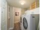 Bright laundry room featuring a washer, dryer, white cabinets, and an adjacent bathroom at 4343 Nw 80Th Ave # 8, Ocala, FL 34482