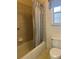 Compact bathroom featuring tub with shower, neutral tile, and standard toilet at 5980 Se 4Th Pl, Ocala, FL 34472