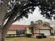 House with a red roof and large tree in front at 5980 Se 4Th Pl, Ocala, FL 34472