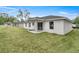 Back of the house with covered patio and grassy backyard at 6068 Nw 57Th Ave, Ocala, FL 34482