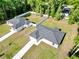 Aerial view showcases two similar single-story homes with fenced backyards, long driveways, and lush green lawns at 6088 Nw 57Th Ave, Ocala, FL 34482