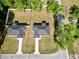 Aerial view showcases two similar single-story homes surrounded by lush lawns and trees, with long driveways at 6088 Nw 57Th Ave, Ocala, FL 34482