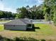 Back view of a gray single-story home featuring a well-maintained lawn and a white fenced yard at 6088 Nw 57Th Ave, Ocala, FL 34482