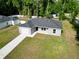 Inviting single-story home with a gray exterior, dark roof, well-kept lawn, and a convenient attached garage at 6088 Nw 57Th Ave, Ocala, FL 34482