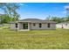 Back of a new home featuring gray exterior, covered patio, and a large yard at 6088 Nw 57Th Ave, Ocala, FL 34482