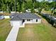 Beautiful single-story home featuring a gray exterior, dark roof, attached garage, and a well-manicured lawn at 6088 Nw 57Th Ave, Ocala, FL 34482