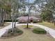 Brick home with circular driveway, lush landscaping, and mature trees at 7267 Se 12Th Cir, Ocala, FL 34480