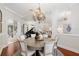 Bright dining room featuring a round table, chandelier, and adjacent living space at 7267 Se 12Th Cir, Ocala, FL 34480