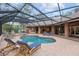 Kidney-shaped pool with covered patio and lounge chairs at 7267 Se 12Th Cir, Ocala, FL 34480