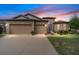 Two-story house with a three-car garage and landscaped lawn at sunset at 7646 Sw 100Th Ct, Ocala, FL 34481