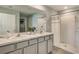 Elegant bathroom with dual sinks, marble countertops, and a shower at 8503 Las Palmas Way, Wildwood, FL 34785