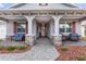 Front porch with stone pillars, red shutters, and a view of the front door at 8749 Sw 93Rd Cir, Ocala, FL 34481