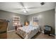 Bedroom with floral-print bed, two windows, and a Gator-themed media stand at 876 Ne 71St Ln, Ocala, FL 34479