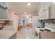 Bright kitchen featuring white cabinetry, a tile backsplash, and a view into the sunny breakfast nook at 9051 Sw 96Th Ln # B, Ocala, FL 34481